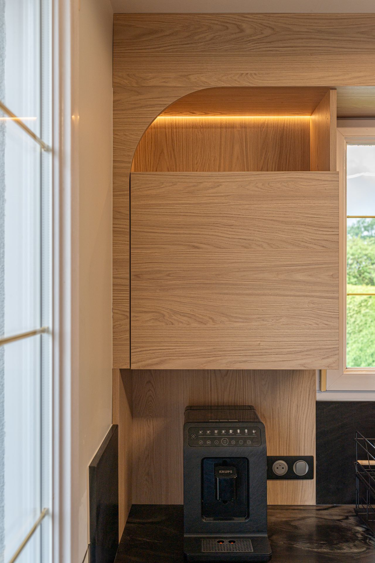Détail meuble haut en bois et éclairage intégré dans une cuisine moderne et chaleureuse - amenagement interieur
