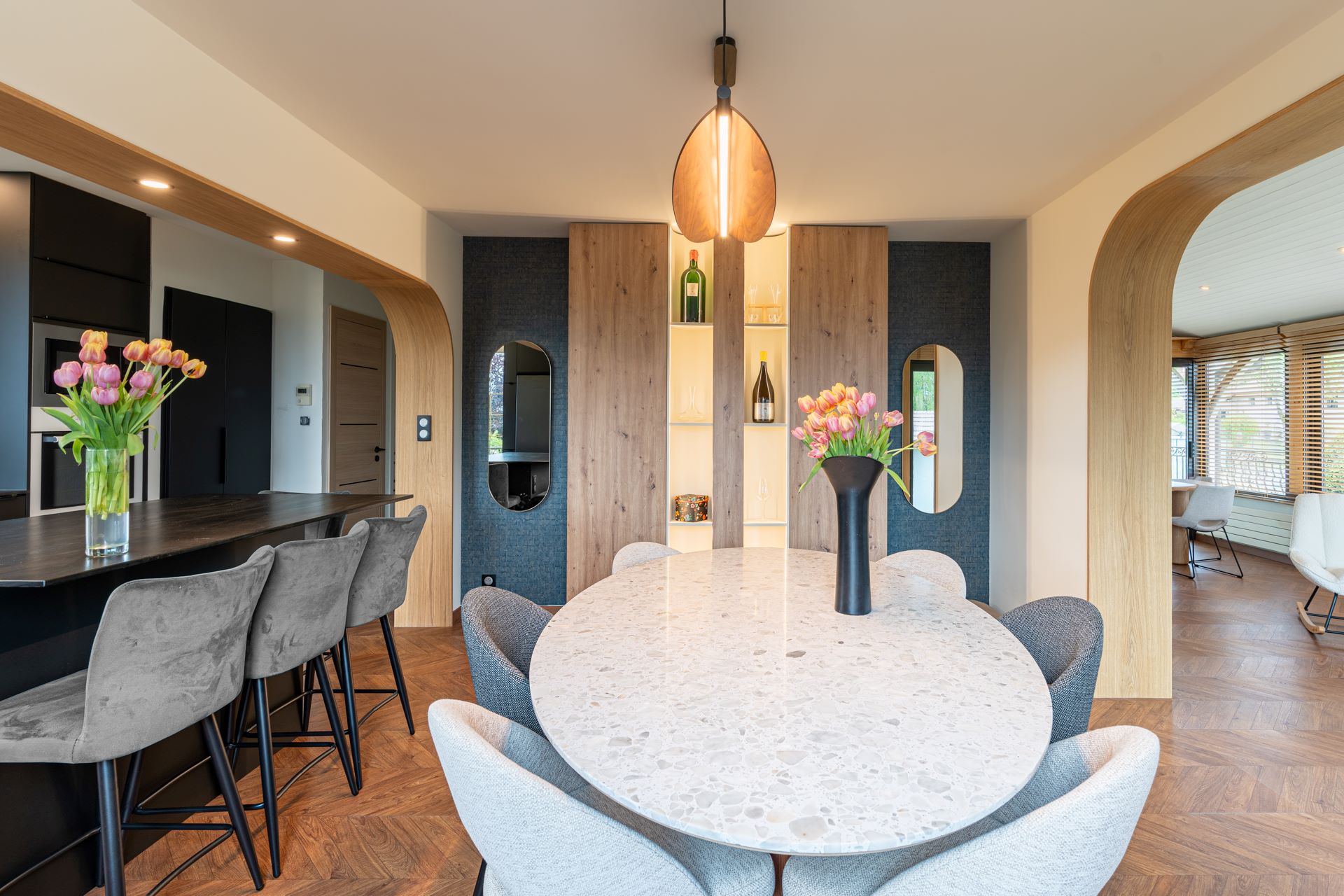 Renovation Salle à manger moderne avec table ronde minérale, bois naturel et niches éclairées