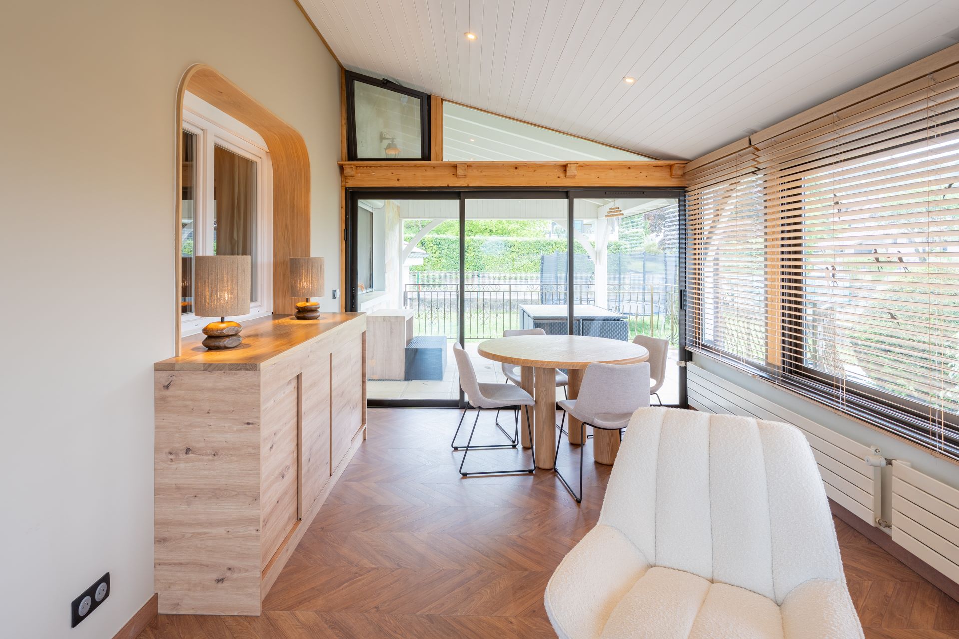 Vue du séjour lumineux avec bois, stores – rénovation intérieure maison moderne en Haute-Savoie.