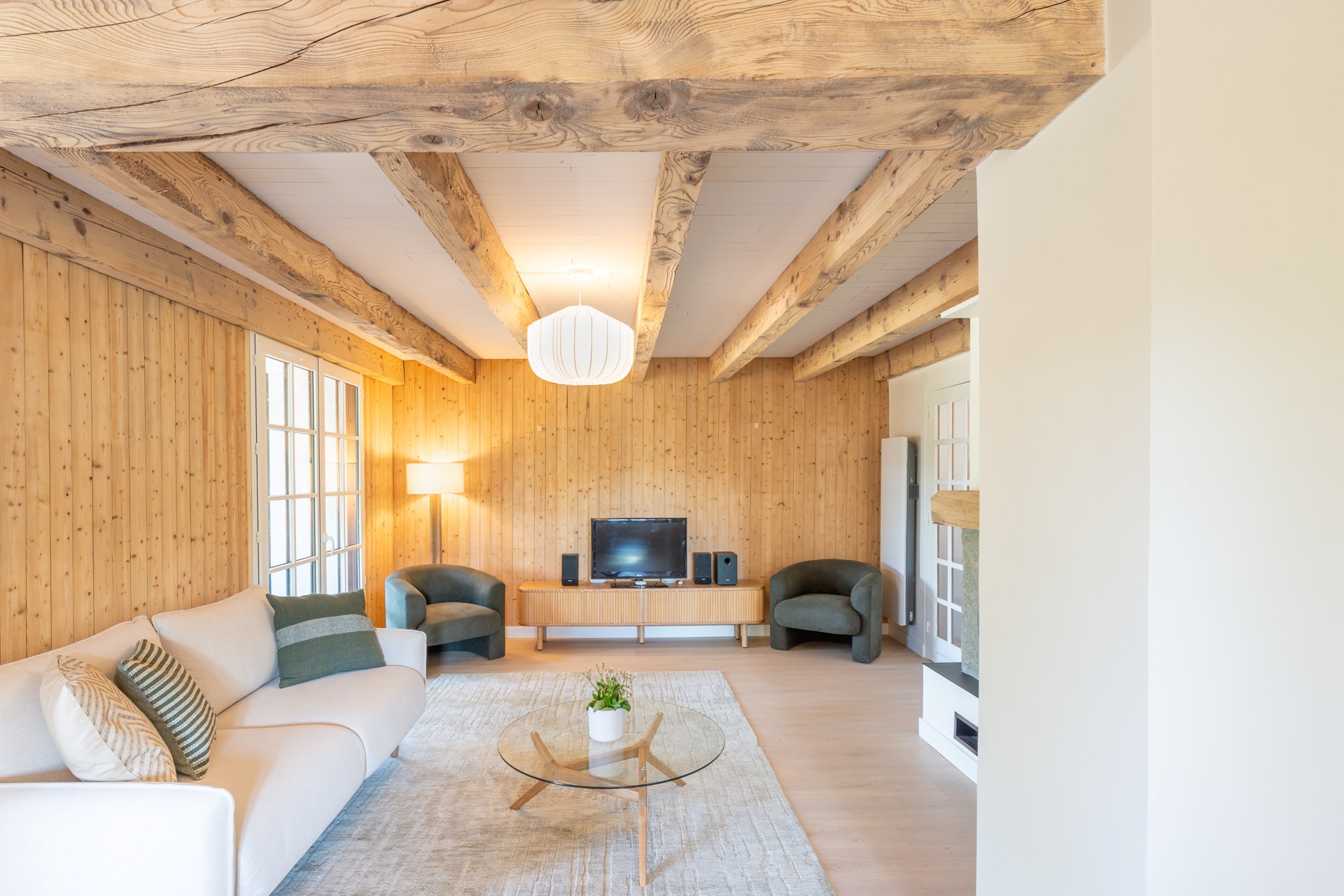 Salon rénové d’une maison ancienne à Menthonnex-sous-Clermont avec poutres apparentes restaurées